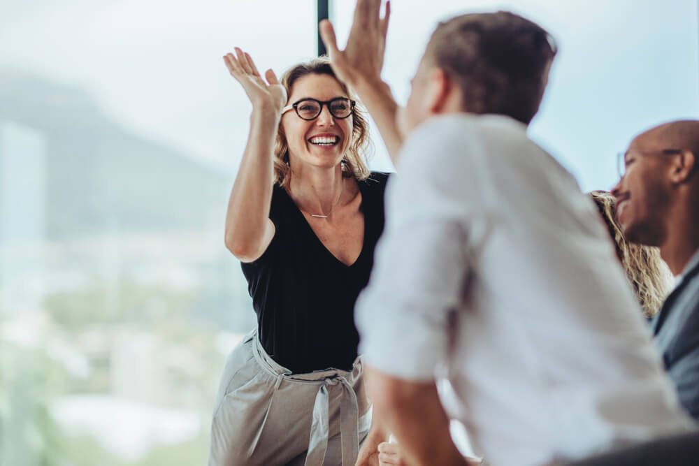 Businesswoman giving a high five to male colleague