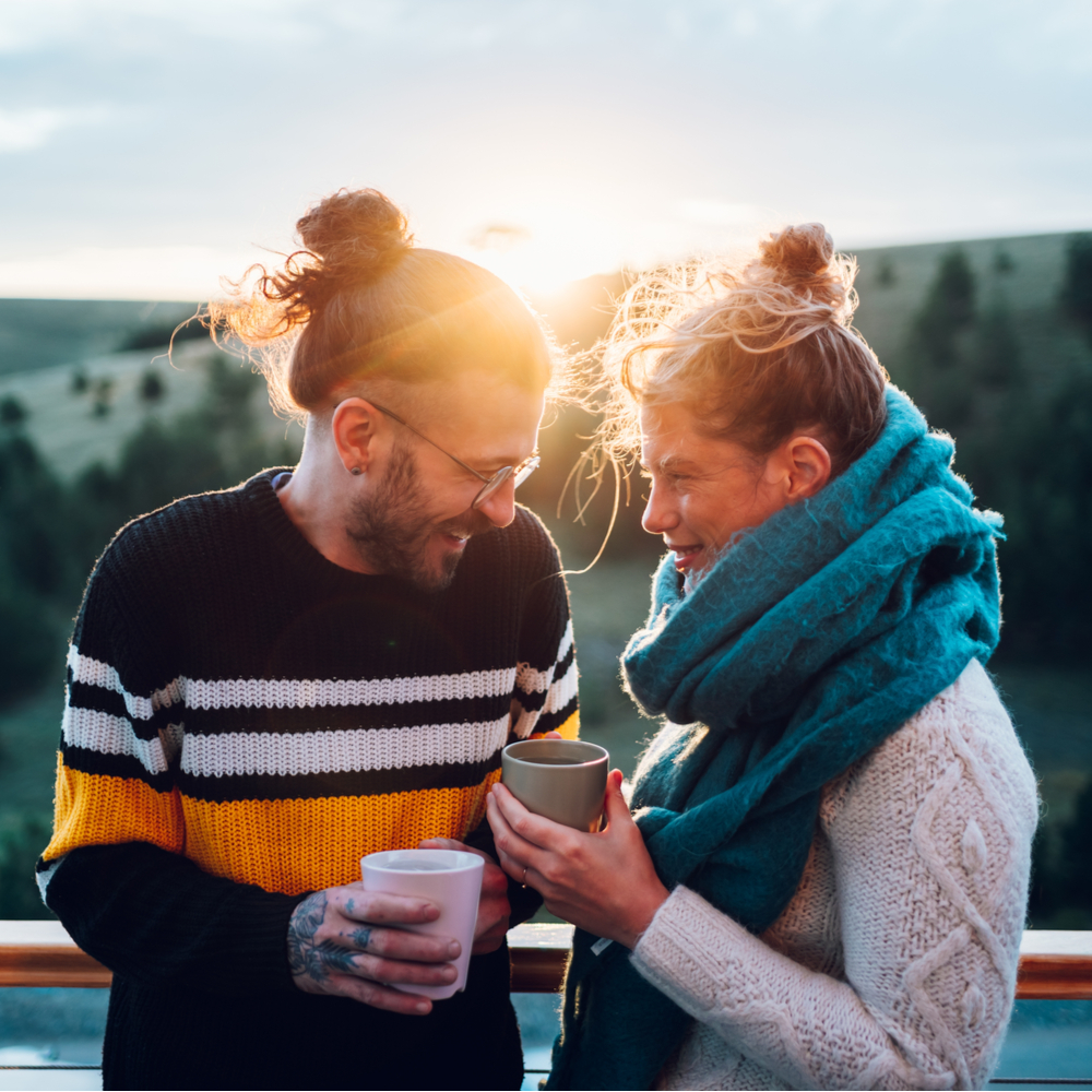 Happy couple enjoying morning coffee and looking at each other