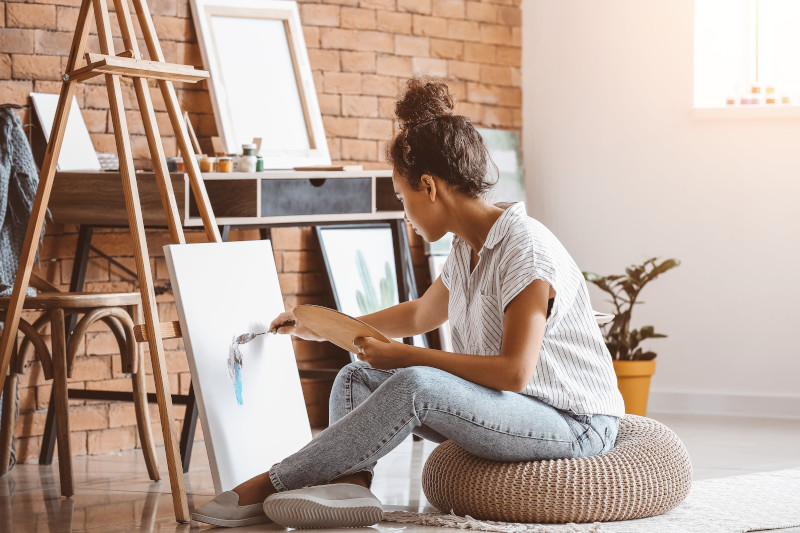 Beautiful female artist painting in studio