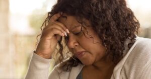 Sad and tired woman hold her hand near head